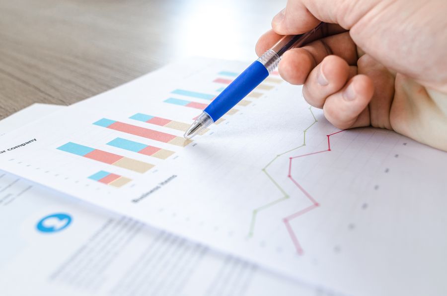 Financial charts and graphs on a dark surface, showing revenue and cash-flow lines.